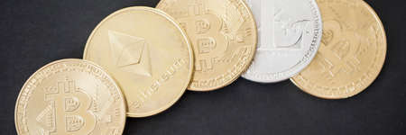 Panorama of golden and silver bitcoin, ethereum and litecoin cryptocurrency on a black surfaceの写真素材