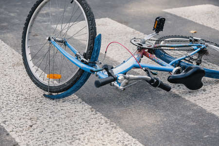 Blue child's bicycle lying on a pedestrian crossing after a traffic accidentの写真素材