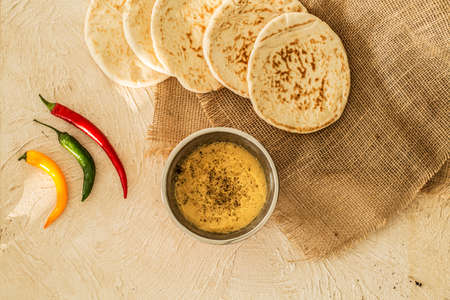 Top view on peppers next to hummus and pita. Arabic cuisine