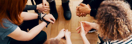 High angle view of hands of people in group therapy, talking and supporting each otherの写真素材