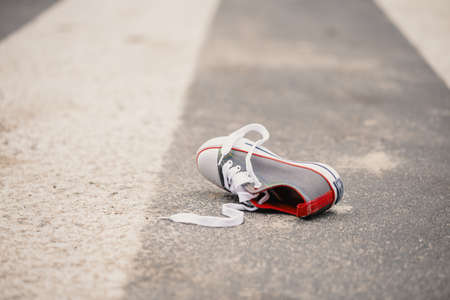 Child's shoe on the street after dangerous traffic incidentの写真素材