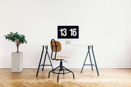 Real photo of a modern home office interior with a computer, desk and chair. Empty wall, place your posterの写真素材