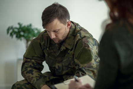 Soldier sitting and talking to his therapistの写真素材