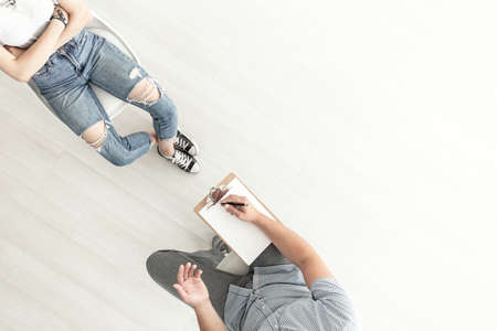 Top view on counselor talking to a difficult teenager. Copy space on backgroundの写真素材