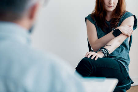 Difficult young girl with alcohol addiction listening to therapistの写真素材