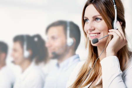 Happy businesswoman with headphone talking with client in the corporation
