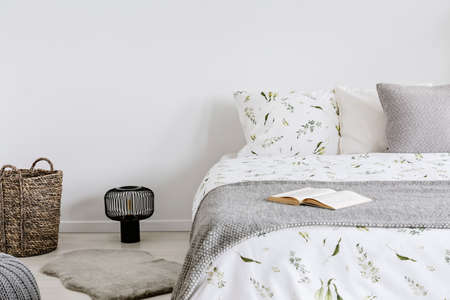 close-up of a bed with eco cotton and wool bedding and pillows in a bright bedroom interior. Real...