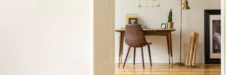 Panorama of white empty wall with copy space in freelancer's interior with gold lamp. Real photoの写真素材