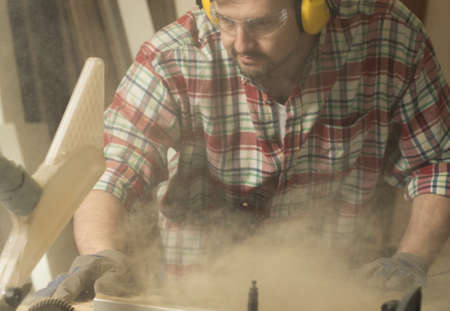 Carpenter working with wood cutting machineの写真素材