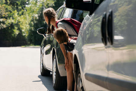 Children walking through the road between cars. Dangerous passageの写真素材