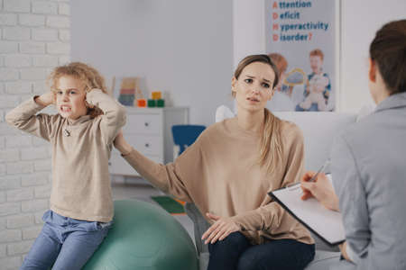 Sad woman and rebellious child with adhd during therapy with psychotherapistの写真素材