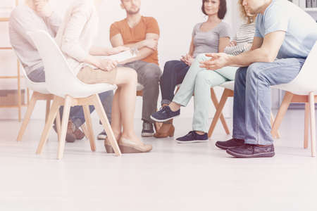 Close-up on people sitting in a circle during group therapy with counselorの写真素材