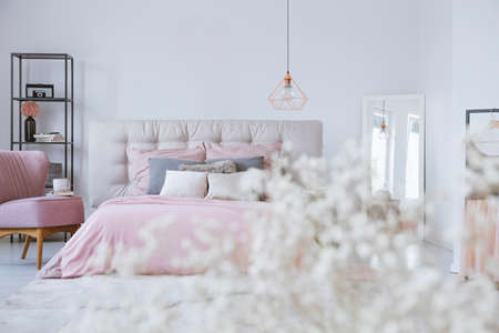 Pastel bedding on king size bed in elegant bedroom interiorの写真素材