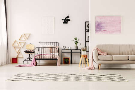 Abstract pastel pink painting above beige stylish couch in scandinavian design kid's bedroomの写真素材