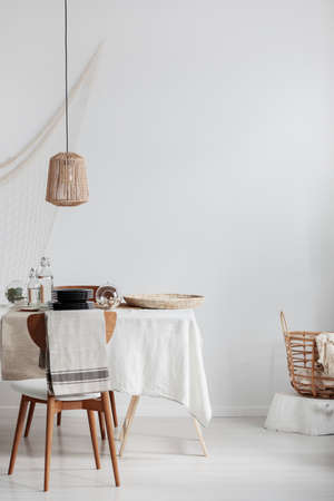 Copy space on empty white wall of bright elegant dining room with table with chairsの写真素材