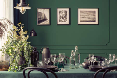 Black and green design of elegant dining table in fashionable interior with gallery of posters on the wallの写真素材