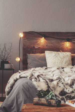 Copy space on empty grey wall of winter bedroom with warm bedの写真素材