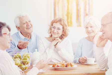 Bright photo of sunday coffee meeting of group of active seniorsの写真素材