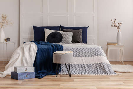 Grey and blue bedding and blanket on comfortable king size bedの写真素材