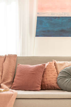 Pillows on grey couch, mockup painting on the wallの写真素材