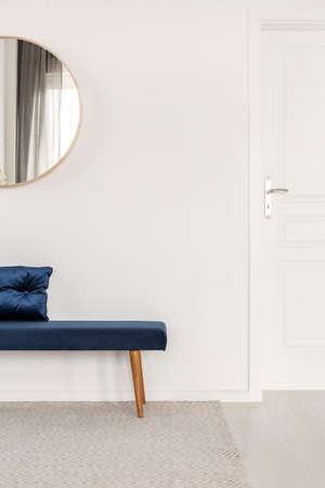 Blue velvet bench with pillow in white and bright corridor