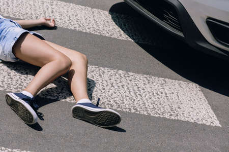 Victim of a traffic accident on pedestrian crossing next to a carの写真素材