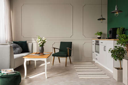Copy space on empty grey wall of stylish open plan kitchen and living room interior