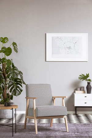 Elegant vintage armchair in grey living room interior with painting on the wall