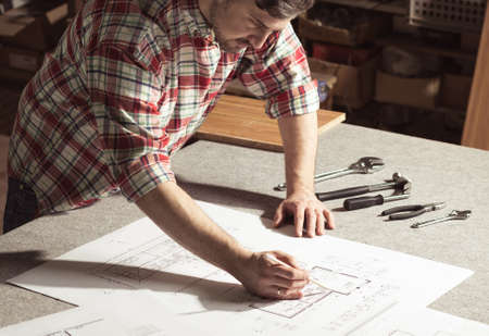 Engineer drawing project on table with tools in the workshopの写真素材