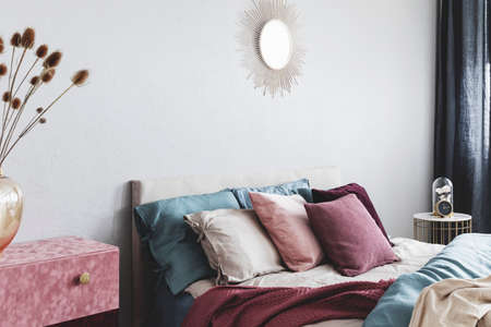 Pillows on comfortable king size bed in chic bedroom interior