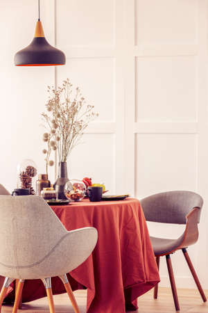 Stylish grey chairs at dining table covered with long tableclothの写真素材
