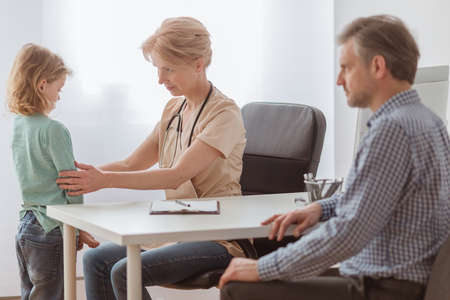 Caring father with cute little son during appointment with pediatricianの写真素材