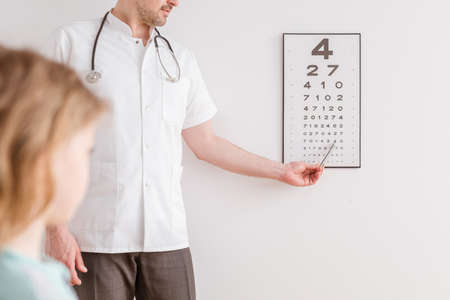 Ophthalmologist shows a small boy an eye test chartの写真素材