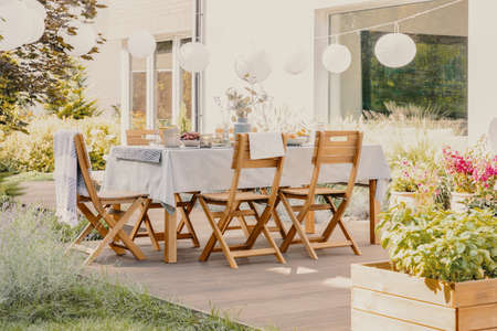 Outdoor dining room with wooden garden furniture set with table and chairsの写真素材