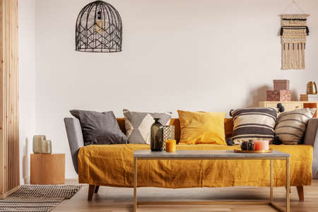 Fashionable living room interior with yellow and grey design and long coffee table in the middleの写真素材