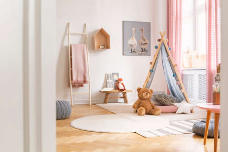 Kid's playroom with tent, teddy bear, carpets and painting on the wall, real photoの写真素材