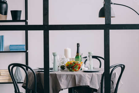 View through the wall with muntins on elegant dining room table covered with grey tableclothの写真素材