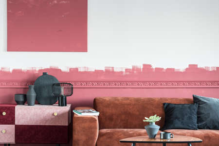 Elegant living room interior with brown couch and white and red ombre wallの写真素材