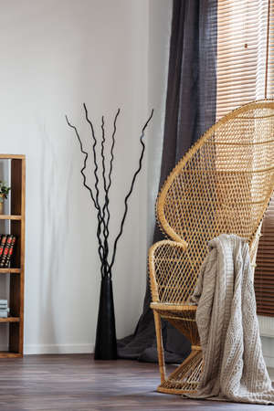 Wicker peacock chair with blanket in comfortable bedroom interior with scandinavian designの写真素材