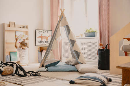 Pillows and carpets on the floor of cozy playroom of single kid, real photoの写真素材
