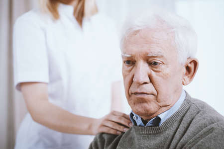 Portrait of senior man with hand of supporting nurse on his shoulderの写真素材