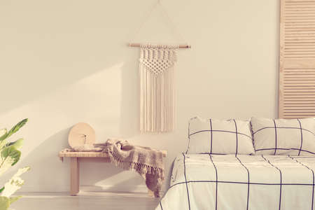 Handmade macrame on empty white wall of scandinavian bedroom interiorの写真素材