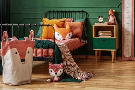Fox theme in cute bedroom interior with green wall and orange beddingの写真素材