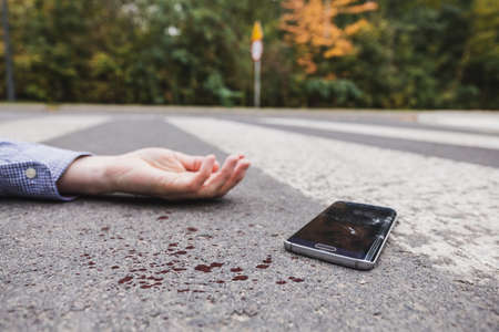 The hand on the street and the phone next to itの写真素材