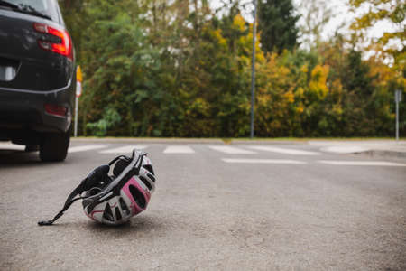 Helmet on the street after bicycle and car accidentの写真素材