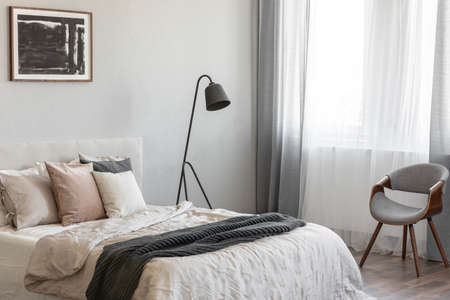 Elegant bedroom interior with king size bed in fashionable apartment, real photoの写真素材