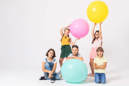 Group of happy kids at school playing with colorful balloonsの写真素材