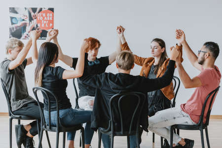 Group of teenagers holding their hands together on a therapy