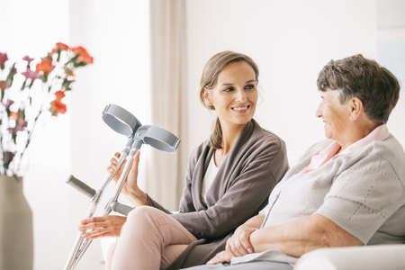 Young caregiver sitting with her older ward