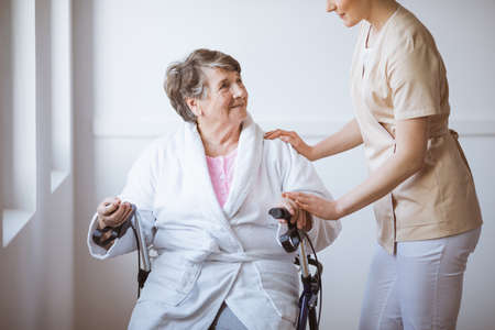 Older sick woman sitting on a walker in a hospital